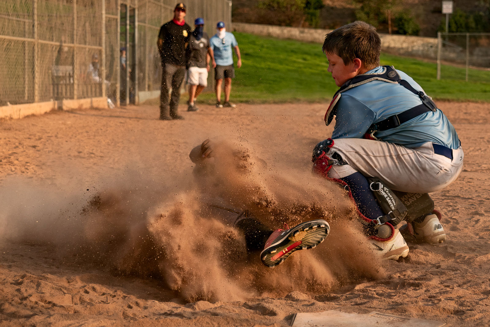 A young player with the South Bay Hawks slides into home plate as an opponent with the Santa Monica Zephyrs applies the tag during the Craig Outlaw Tournament 11U game between the Santa Monica Zephyrs and the South Bay Hawks at Edward Vincent Junior Park in Inglewood, California